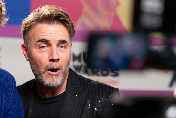 A photo of singer Gary Barlow posing in front of a camera