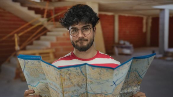A man peering over a map, looking unimpressed